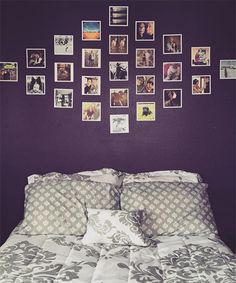 a bedroom with purple walls and pictures on the wall above the headboard, along with a bed