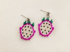 a pair of pink and green beaded fruit earrings on white background with space for text