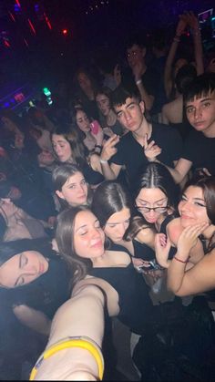 a group of young people standing next to each other in front of a crowd at a nightclub