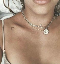 a close up of a woman wearing a necklace with a heart and cross on it