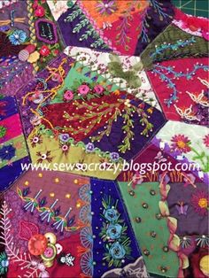 a colorful patchwork quilt with lots of different colors and designs on the fabric,