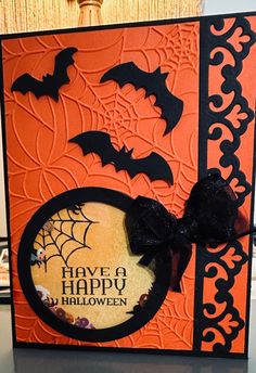 an orange and black halloween card with bats