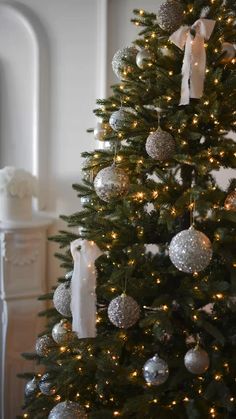 a christmas tree decorated with silver and white ornaments