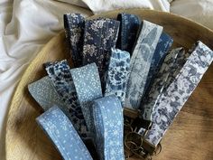 a bunch of blue and white cloths on a wooden tray with keychains