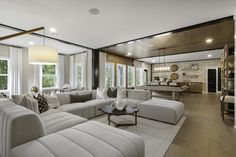 a living room filled with lots of furniture next to a kitchen and dining room table