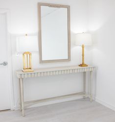 a white table with a mirror and lamp on it