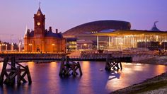 a large building with a clock tower next to a body of water