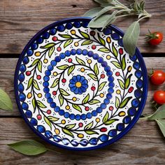 a blue and white plate sitting on top of a wooden table next to some tomatoes