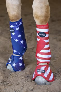 the legs and feet of a horse wearing socks with american flags on them, standing in dirt