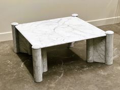 a white marble coffee table sitting on top of a floor