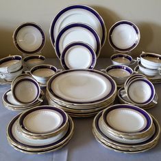 a table topped with lots of white and blue plates covered in silver rimmed dishes