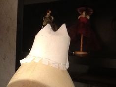 a close up of a dress on a mannequin's head with other dresses in the background