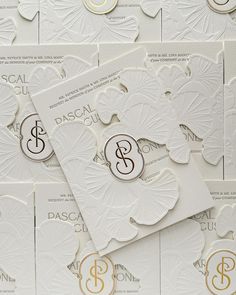 the wedding stationery is laid out on top of each other with monogrammed initials