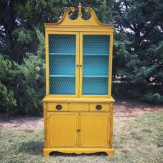 an old china cabinet painted yellow and blue