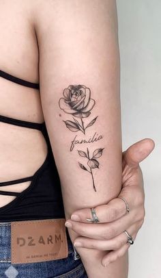 a woman's arm with a rose tattoo on the left side of her arm