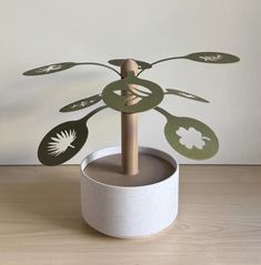 a plant made out of paper sitting on top of a wooden table