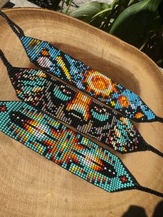 two beaded ties sitting on top of a wooden bowl