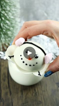 a person is holding a snowman ornament