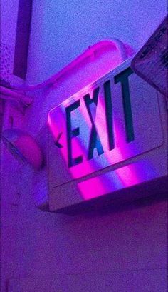 the exit sign is lit up with purple light