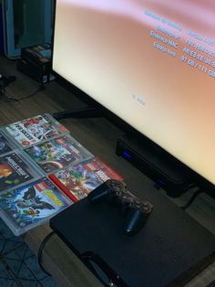 a video game console sitting in front of a flat screen tv with games on it