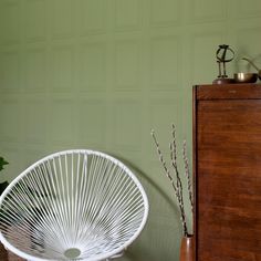 a white chair sitting next to a wooden dresser