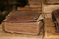 several old books are stacked on top of each other