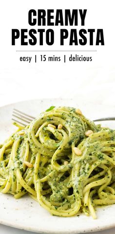 a white plate topped with pasta covered in pesto