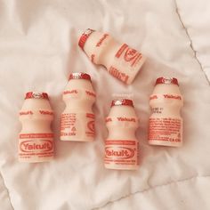 six bottles of stuff sitting on top of a white bed sheet with the word stuff written on them