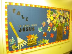 a bulletin board with fall leaves on it and a broom in front of the sign