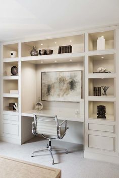 an office with white bookcases and a desk