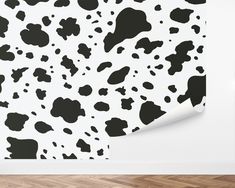 a black and white cow print wallpaper in an empty room