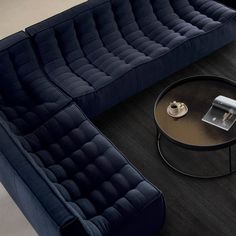 a living room with two blue couches and a coffee table on the floor in front of it