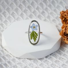 a ring with flowers painted on it sitting next to a dried flower headband holder