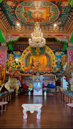 the interior of a buddhist temple with chandelier and decorations