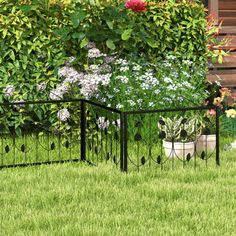 a black iron fence with flowers growing on it