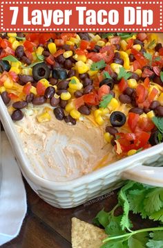 a white casserole dish filled with black beans, corn and cilantro