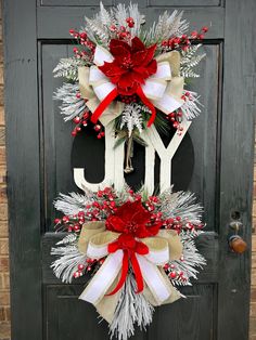 a christmas wreath with the word joy hanging from it's side on a door