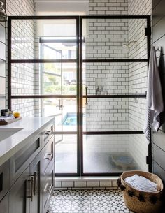 an open door leading to a bathroom with white tile walls and flooring on the outside