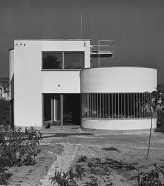 a black and white photo of a building with a round window on the front side