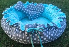 a blue and white polka dot dog bed in the grass