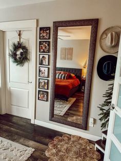 a mirror sitting on top of a wooden floor next to a bed in a bedroom