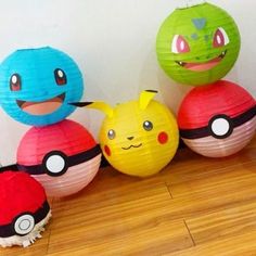 paper lanterns with pokemon characters on them sitting on a wooden floor next to each other