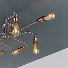 an overhead light fixture with five lights and one bulb on the end, hanging from a ceiling