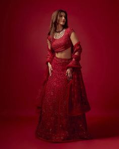 a woman in a red dress posing for the camera with her hands on her hips