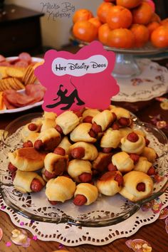 hot dogs and buns on a plate with a sign that says her disney dress up