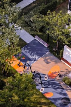 an aerial view of a basketball court in the middle of a park with trees surrounding it