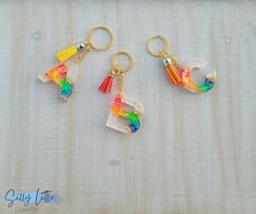 three key chains with different colored tassels hanging from them