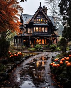 a large house with lots of pumpkins on the ground in front of it and trees