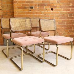 three chairs sitting next to each other in front of a brick wall