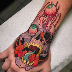 a man's hand with a skull and octopus tattoo on it